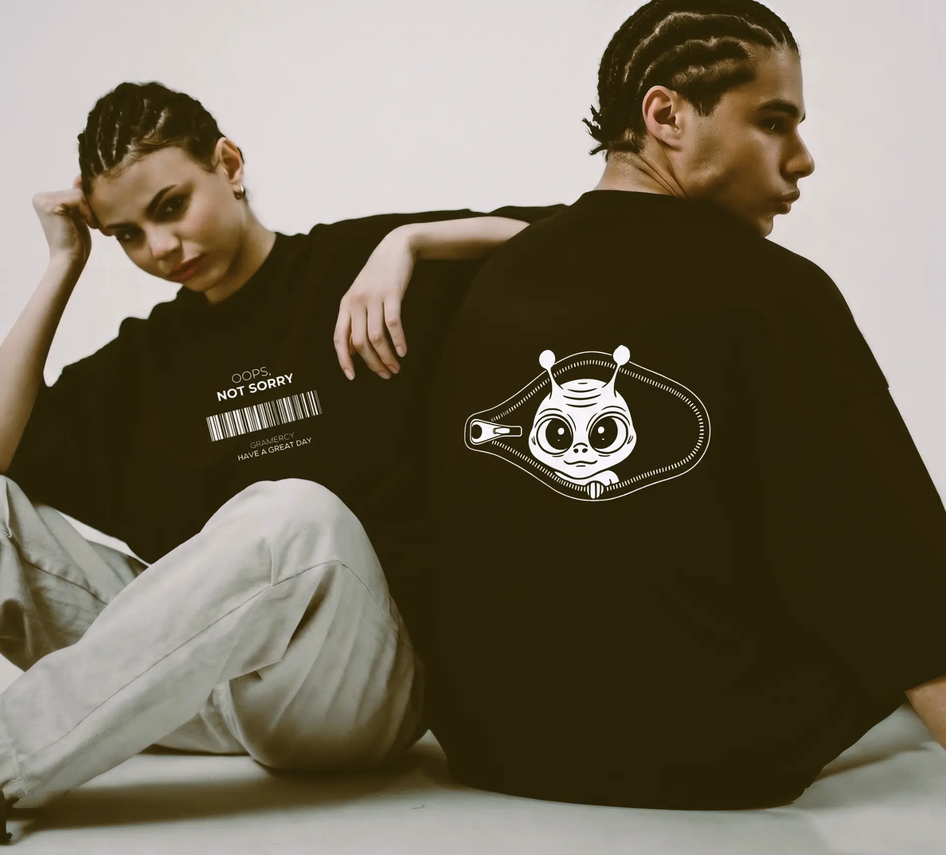Two models in black BLACK tees showing the barcode and alien back prints